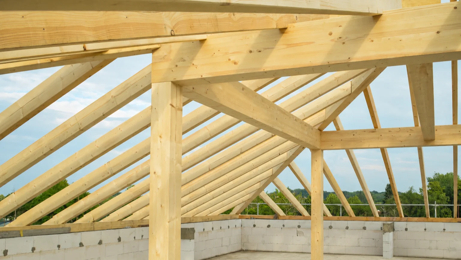 Cubierta de madera de una vivienda de obra nueva en construcción, con la geometría del tejado definida por la estructura.